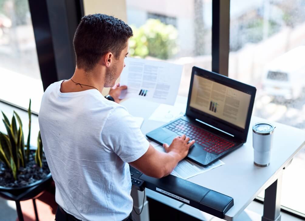 A man infront of his laptop standing