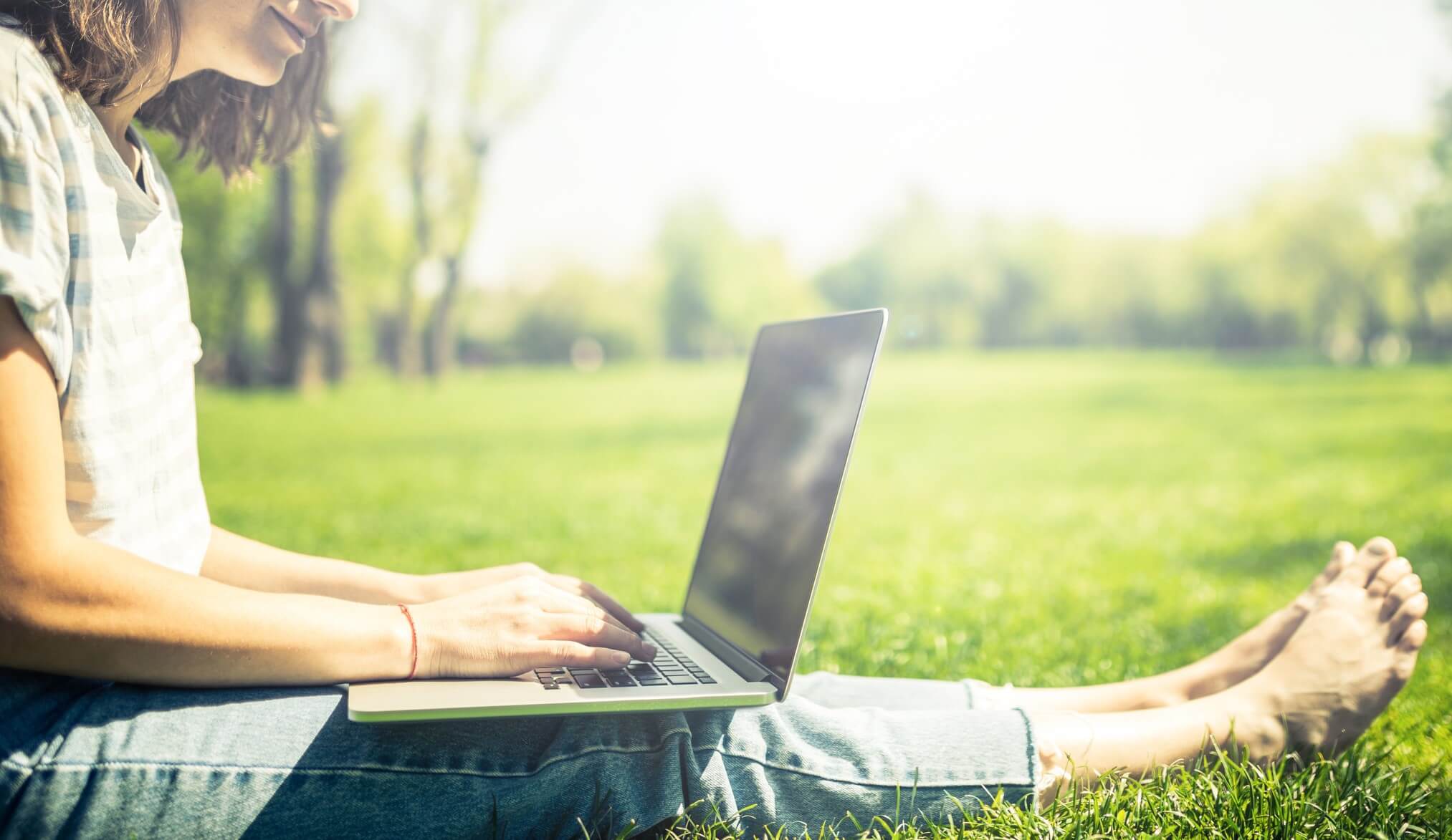A woman using a laptop in a park