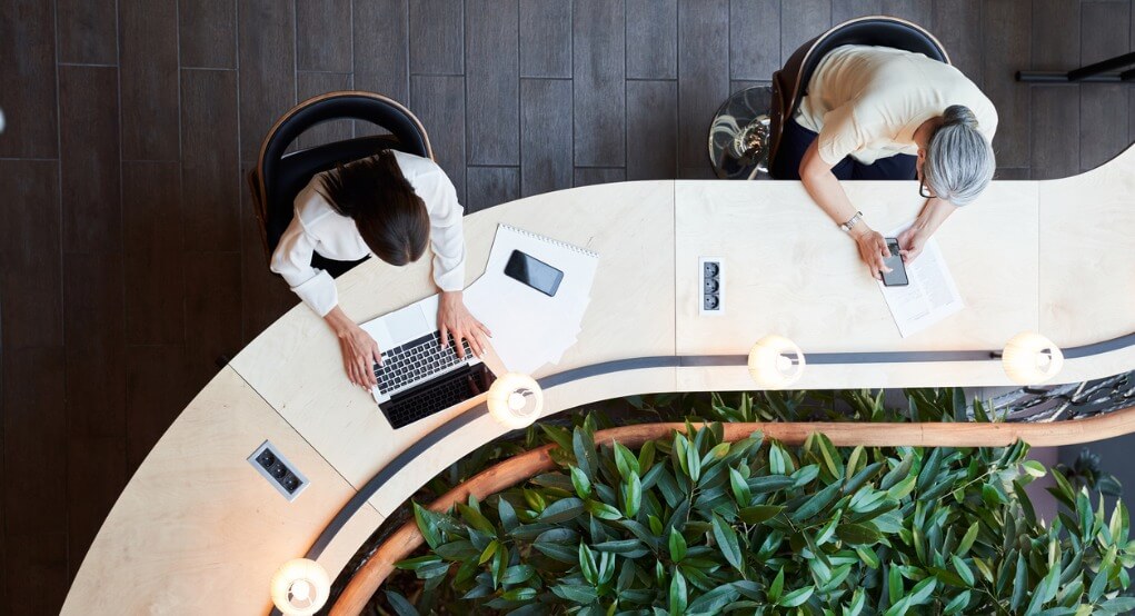 young student and woman working at the same time on curved desk