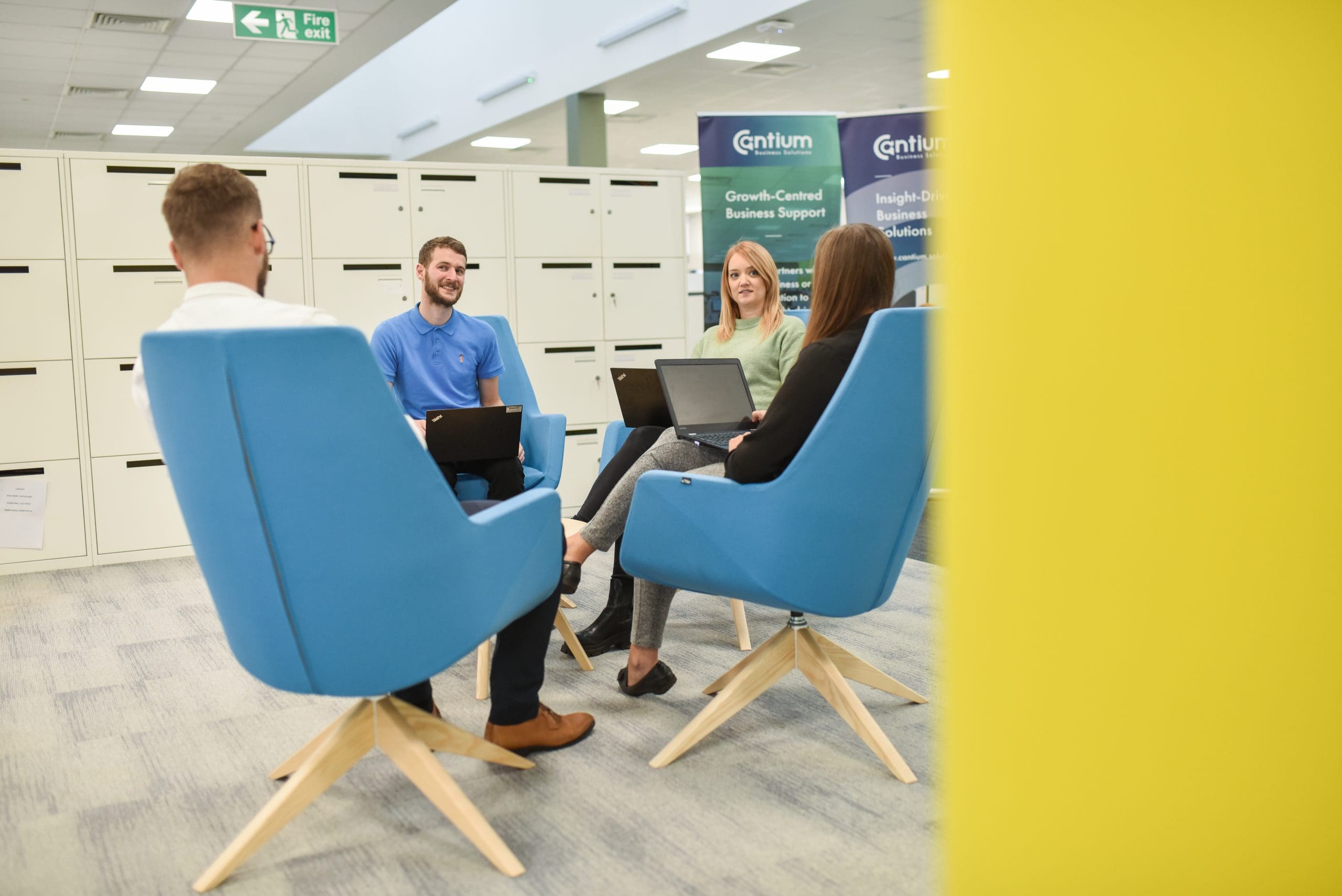Photograph of four Cantium employees having a meeting on blue chairs across a table