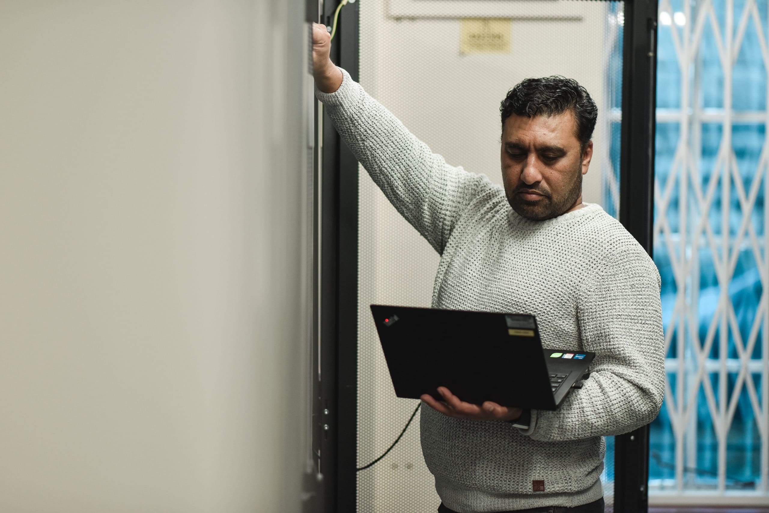Cantium employee working in the data centre with servers and their laptop.