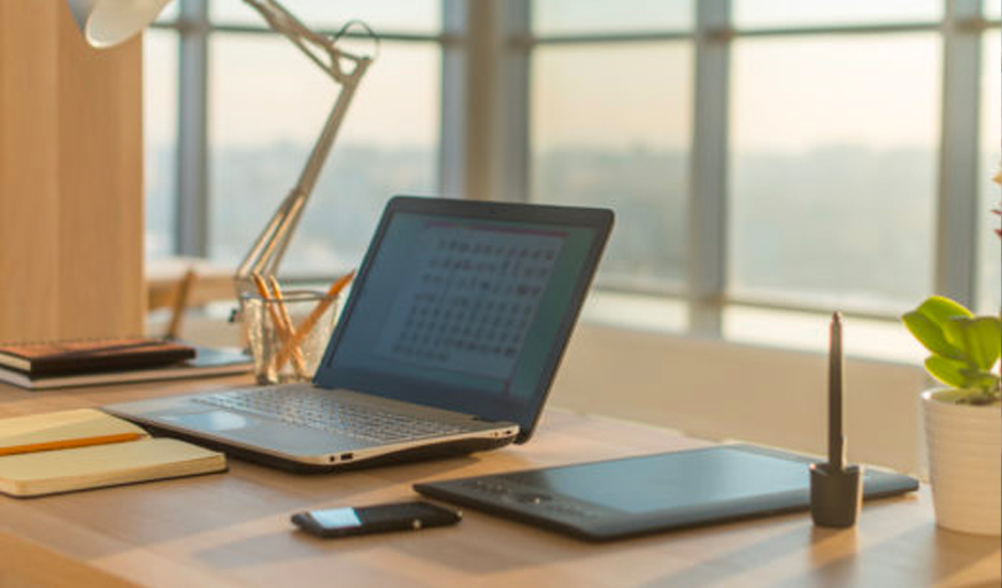 Photograph of a remote working desk, laptop and work set up