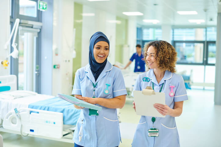 Photograph of two nurses walking through a hospital