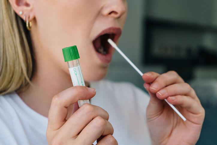 Photograph of somebody completing a mouth swab for covid-19 test