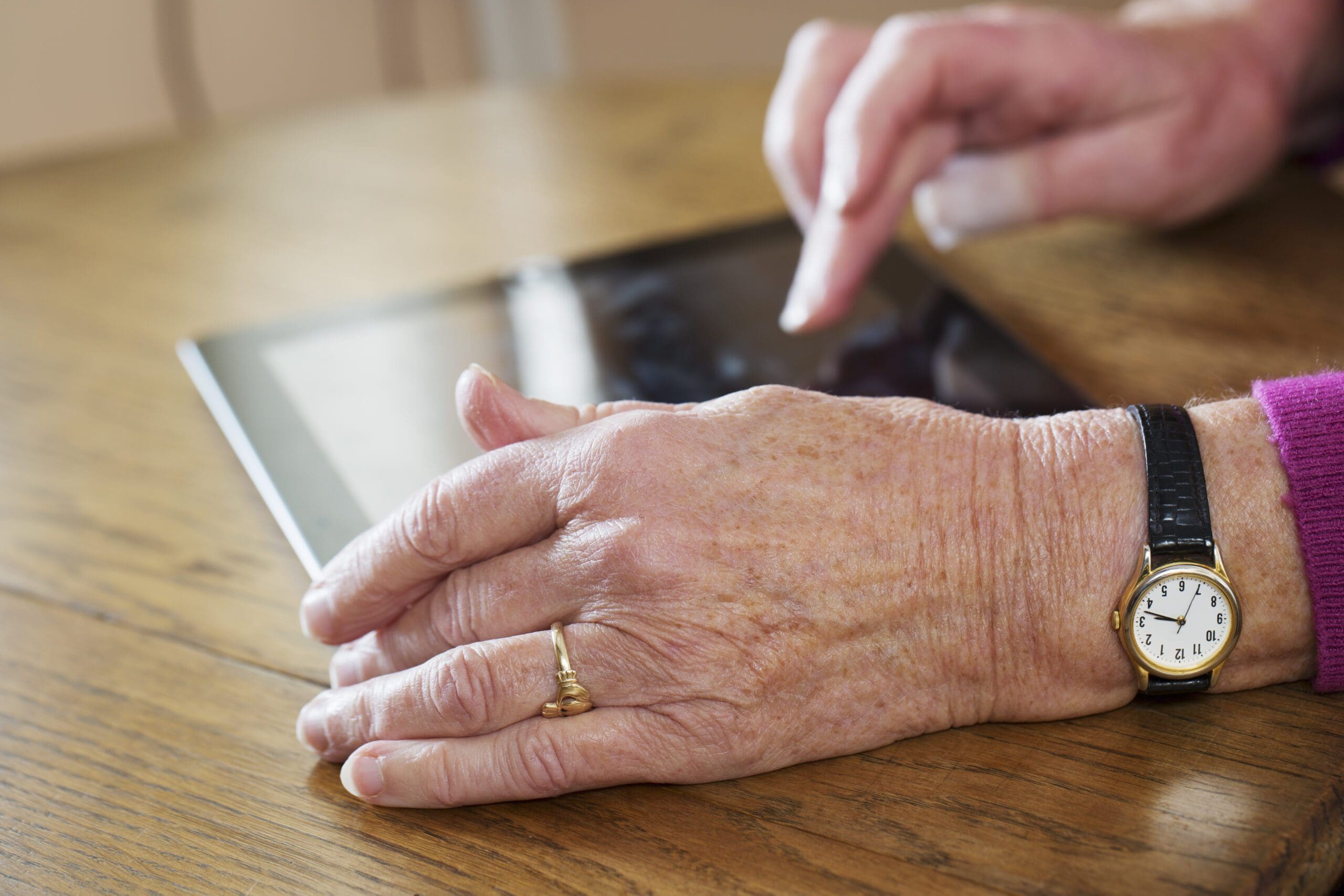 Senior woman's hands using digital tablet