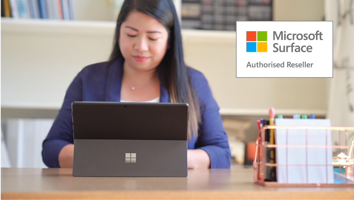 Photograph of a person working at a Surface Laptop with the Authorised Reseller logo